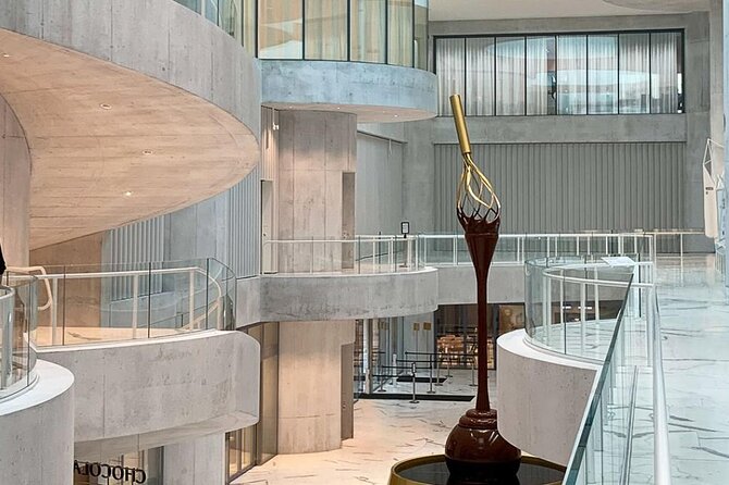 Tour in Lindt Home of Chocolate Museum From Zurich With pickup - The chocolate fountain and the museum entrance
